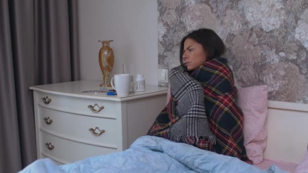 Девочка сидит на кровати больная — стоковое видео