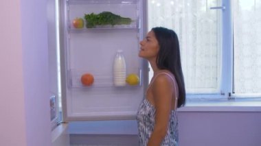 Kız buzdolabından çıkar.