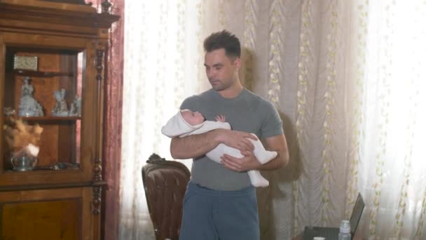 muž drží doma v náručí dítě