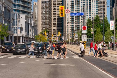 Toronto, Kanada - 22 Haziran 2019: Toronto 'da Queens Quay W caddesini geçen bir kalabalık