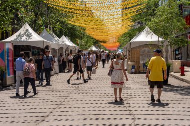 Montreal, CA - 1 Temmuz 2019: Gay Köyü 'ndeki Saint-Catherine Caddesi' nde Gökkuşağı Topları Sanat Kurulumunun altında yürüyen insanlar