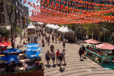 Montreal, CA - 1 Temmuz 2019: Gay Köyü 'ndeki Saint-Catherine Caddesi' nde Gökkuşağı Topları Sanat Kurulumunun altında yürüyen insanlar