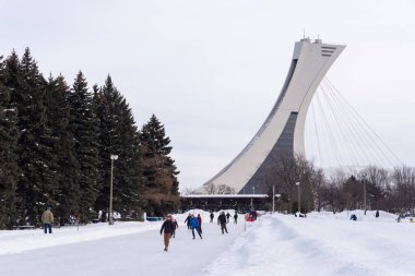 Montreal, CA - 15 Şubat 2020: Park Maisonneuve buz pateni pistinde arka planda Olimpiyat Stadyumu Kulesi ile buz pateni.