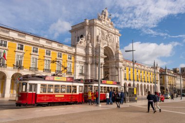 Lizbon, Portekiz - 2 Mart 2020: Arco da Rua Augusta 'nın önündeki 28 numaralı Praca do Comercio' da iki kırmızı tramvay