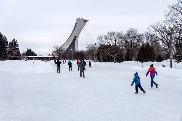 Montreal, CA - 15 Şubat 2020: Park Maisonneuve buz pateni pistinde arka planda Olimpiyat Stadyumu Kulesi ile buz pateni.