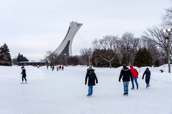 Montreal, CA - 15 Şubat 2020: Park Maisonneuve buz pateni pistinde arka planda Olimpiyat Stadyumu Kulesi ile buz pateni.
