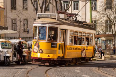 Lizbon, Portekiz - 8 Mart 2020: Alfama bölgesindeki ünlü sarı tramvaya binen turistler