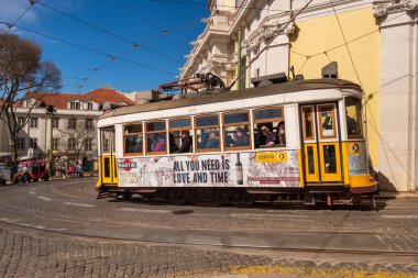 Lizbon, Portekiz - 8 Mart 2020: Alfama bölgesindeki ünlü sarı tramvaya binen turistler