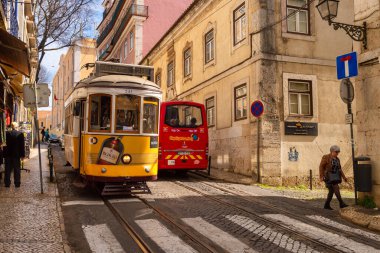 Lizbon, Portekiz - 8 Mart 2020: Alfama bölgesindeki ünlü sarı tramvaya binen turistler