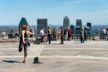 Montreal, CA - 18 May 2020: Young woman streching and working out outdoors at the top of Mount Royal during Covid-19 pandemic clipart