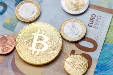 Calais, Fransa - 17 Haziran 2018: Bitcoin madeni para ve Euro banknotlarının üzerinde oturan Euro sikkeleri