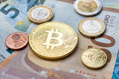 Calais, Fransa - 17 Haziran 2018: Bitcoin madeni para ve Euro banknotlarının üzerinde oturan Euro sikkeleri
