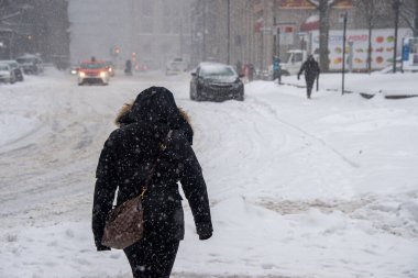 Montreal, CA - 7 Şubat 2020: Montreal şehir merkezinde kar fırtınası sırasında yürüyen kadın.