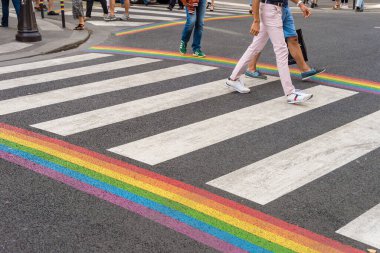 Paris, France - 24 June 2018: Gay pride flag crosswalk in Paris gay village with people crossing clipart