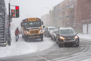 Montreal, CA - 21 Kasım 2016: Sezonun ilk karı şehre düştü. Kar fırtınası sırasında sarı okul otobüsü ve trafik.