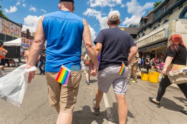 Toronto, CA - 24 Haziran 2017: Gay çift el ele tutuşup Gay Köyü 'nde Church Caddesi' nde yürüyor.