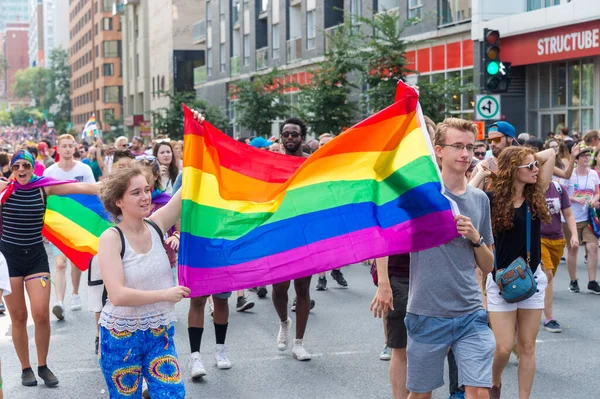 カナダ モントリオール 2017年8月20日 2人の若者がモントリオールゲイプライドパレードで大きなゲイの虹の旗を掲げています — ストック写真