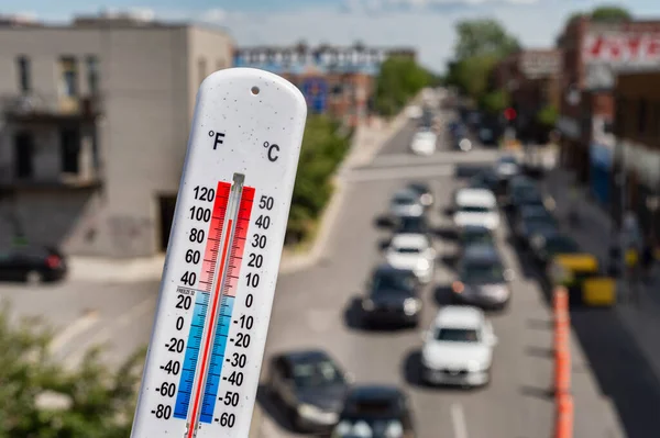 モントリオールの熱波の間の車や交通の前の温度計 — ストック写真