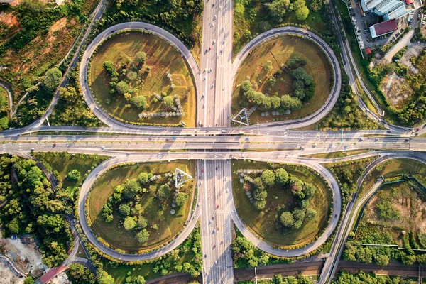 Bir otoyolda yonca yaprağı ile bir hava çekim Üstgeçit. Otoyol trafik ile dolu ama kalabalık değil. Düşük güneş pozisyon uzun gölge desenleri oluşturur. Altın saat sırasında vurdu.