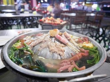 Bir çeşitli et, sebze ve bir Tayland tarzı sıcak pot pişirildikten deniz ürünleri. Tipik mookata Restoran ayarı.