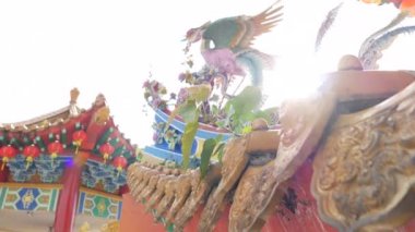 Kamera hareketi arkadan aydınlatmalı phoenix ortaya koymaktadır. Mercek parlaması güneş tarafından oluşturulur. Bir geleneksel Çince Budist tapınağı arka planda mimarisidir. Kırmızı Fener tapınak yapısı asılı.