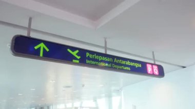 Havaalanında uluslararası kalkış tabelası. Tabela İngilizce ve Malaycadır. Tabela tavandan asılır..