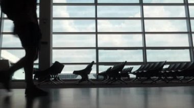 Havaalanı koridorunda yürüyen iki erkek yolcu.