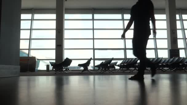 Tres viajeros caminando a través de un pasillo del aeropuerto . — Vídeos de Stock