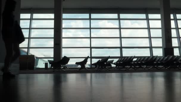 Two travellers walking across an airport hallway. — Stock Video