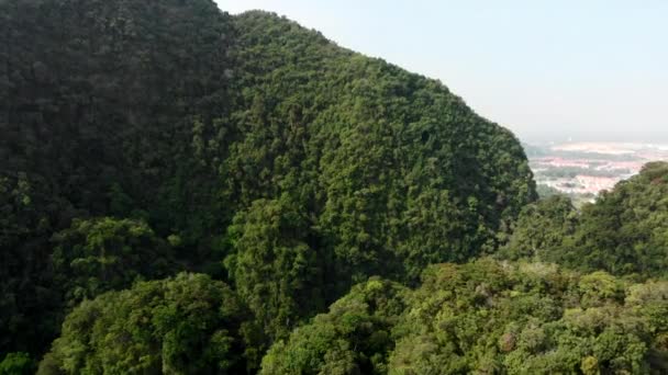 An aerial shot of a limestone hill tilting down to a lake — Stock Video