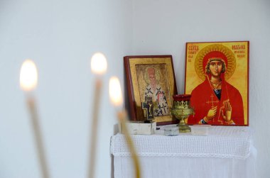 Ortodoks kilisesindeki ikonların önündeki mumlar. Manastırda yanan mum, haç ve simgeler