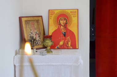 Ortodoks kilisesindeki ikonların önündeki mumlar. Manastırda yanan mum, haç ve simgeler