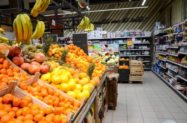 Bosna-Hersek - 15 Mart 2020: Süpermarkette raflarda bulunan ürünler. Meyve ve sebze. Alışverişe. Yerel bakkalda satılık konserve, kutu ve şişeler. Pazarda raflardaki yiyecekler.
