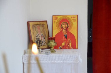 Ortodoks kilisesindeki ikonların önündeki mumlar. Manastırda yanan mum, haç ve simgeler