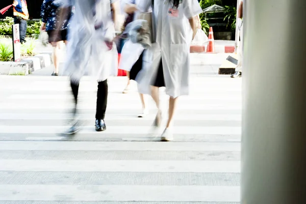 group of people like doctor are walking on cross road with hustle. Take photo to blur with fast motion and slow shutter