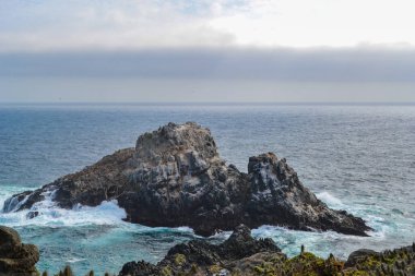 Pasifik Okyanusu mavi sularda deniz kayalıklarla