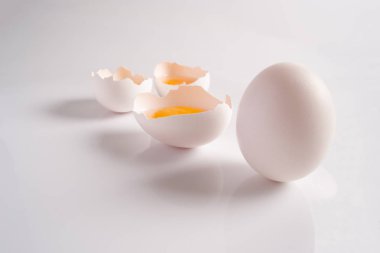 Çiğ beyaz kırık yumurta yumurta kabuğu yarısı ve açık renkli bir bütün yumurta