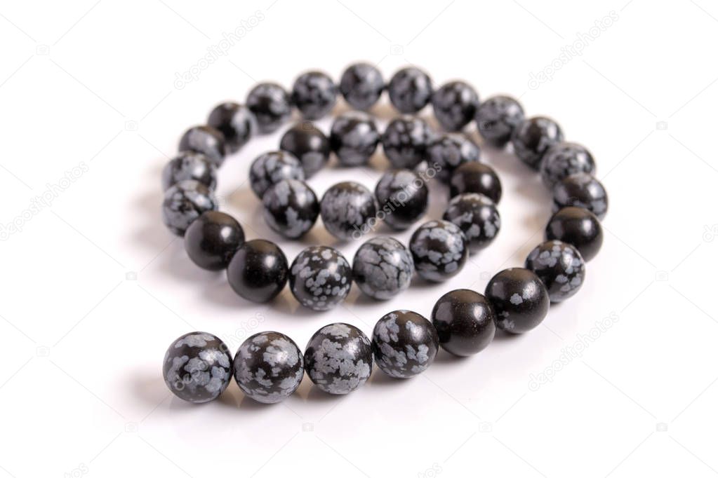 Snowflake obsidian beads on white background