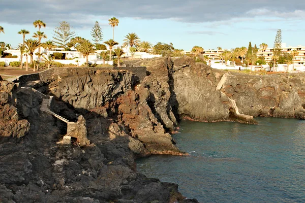 Costa del Silencio - sessizlik Bay arka plan, palmiye ağaçları ile kaya oluşumu ile yüksek volkanik sahil
