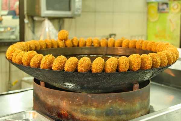 Geleneksel falafel yuvarlak topları sıcak pişirme yağı ile özel tencerede kızartma sonra kuru