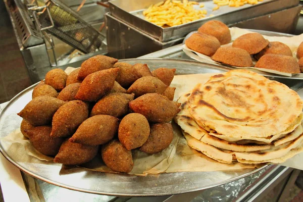 Lübnan restoranında büyük yuvarlak tabakta geleneksel kebbe ve pide ekmeği