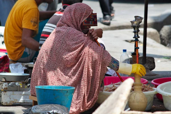 Yerel pazar ve sigara nargile geleneksel renkli maskesi İranlı kadın.