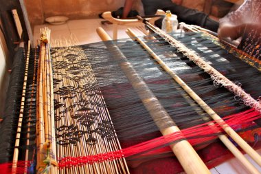 Traditional weaving machine used at home by women to make colorful fabrics for clothes. clipart