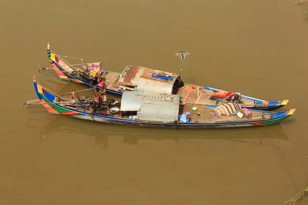 A home on a boat. Cambodian style of life on colorful boat on dirty brown water of wide river.