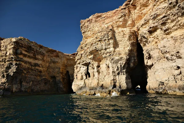 Cílfs altos con cuevas en la isla de Cominotto — Foto de Stock