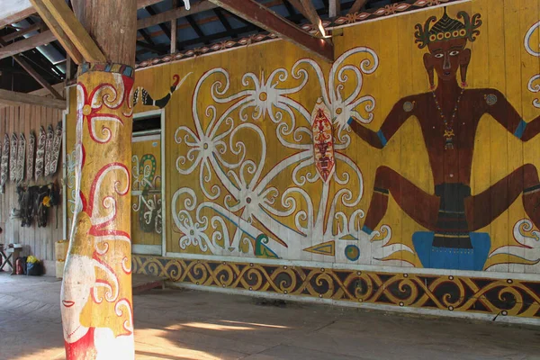 Bornego 'daki Merasa köyünde uzun bir evin dekoratif duvarı. Dayak kabilesinin sembolleri. Ahşap kaplama kalkanlar..
