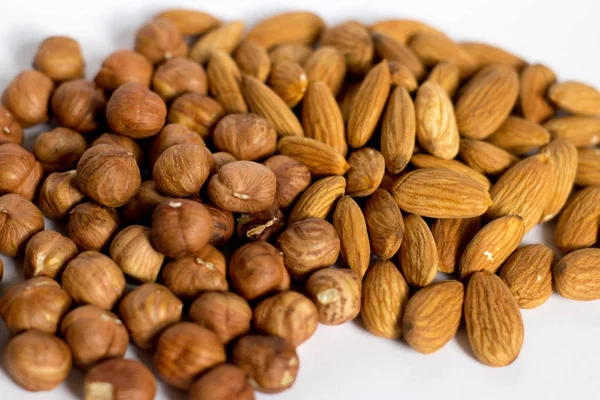 handful of nuts on a white background, almonds and hazelnuts