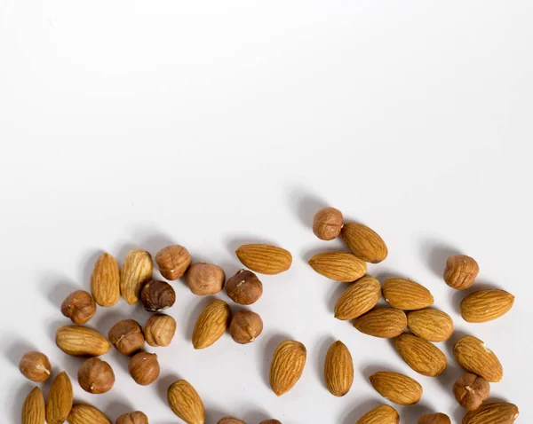 handful of nuts on a white background, almonds and hazelnuts