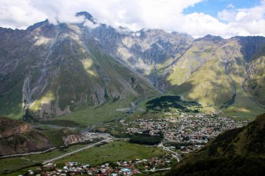 Ana Kafkas (havza) sırtı. Georgia, Kazbegi Köyü (Stepantsminda). Mount Kazbek. Dağlar yaz Gürcü askeri yol. Güzel gökyüzü. Yeşil, yüksek dağlar. Tatil, zam. Gergeti