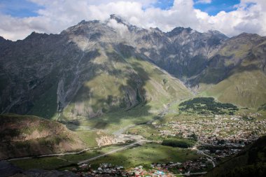 Ana Kafkas (havza) sırtı. Georgia, Kazbegi Köyü (Stepantsminda). Mount Kazbek. Dağlar yaz Gürcü askeri yol. Güzel gökyüzü. Yeşil, yüksek dağlar. Tatil, zam. Gergeti